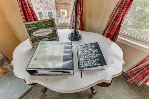 a table with a lamp and books on it at Spacious Condo with View Less Than 1 Mi to Mtn Creek Resort! in Vernon Township