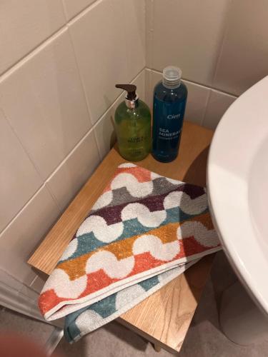 een badkamer met een handdoek op een houten plank naast een wastafel bij Luxury Cosy Retreat Apt in Londen