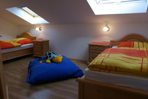 een kinderkamer met 2 bedden en een blauwe deken bij Ferienwohnungen Hollerberg Wohnung 2 in Regen