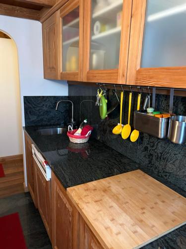 uma cozinha com armários de madeira e uma bancada em Chesa Cotschna em Celerina