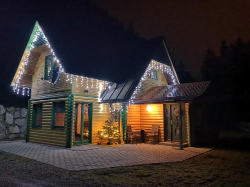 Una casa con luces de Navidad encendidas por la noche en Butterfly Cottage by the Creek, en Tržič