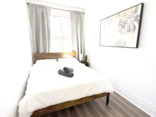 ein Schlafzimmer mit einem Bett mit Hut darauf in der Unterkunft 4-Bed Gem in Little Italy, 5min from Beaubien in Montreal