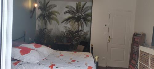een slaapkamer met een bed en palmbomen aan de muur bij Pascal et Domi "l'oasis des pins" in Saint-Biez-en-Belin