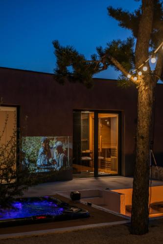 a palm tree in front of a building at night at ARGENTO RESIDENCE in Zagvozd