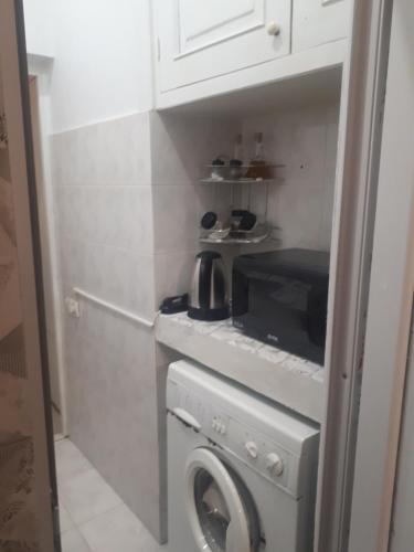 a kitchen with a washing machine and a microwave at Sunflower Hotel in Tbilisi City
