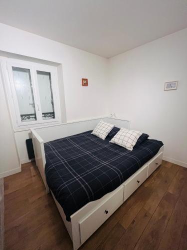a bed in a white room with two windows at Studio neuf au calme proche gare maritime - 7 min in Nantes