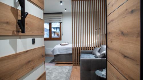 a room with a bed and a sliding door at Regulus apartment Brzeće Kopaonik in Brzeće