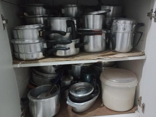 a bunch of pots and pans on a shelf at CASA de 2 QUARTOS in Guaratinguetá