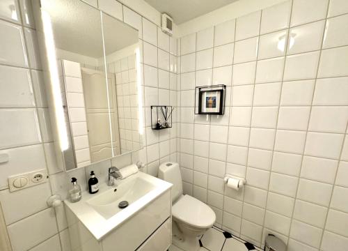 een witte badkamer met een toilet en een wastafel bij Reykjavikurvegur 42 in Reykjavík