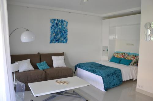 un salon avec un lit et un canapé dans l'établissement Beau studio vu mer juan les pins, à Antibes