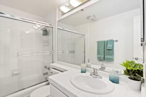 Baño blanco con lavabo y espejo en Stunning Top floor 2BD 2BA Ocean View Santa Monica en Los Ángeles