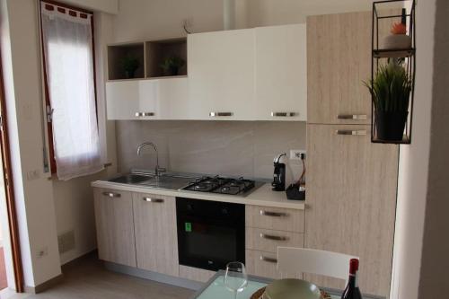 uma cozinha com um lavatório e um fogão forno superior em Casa Smeraldo em San Giovanni Lupatoto