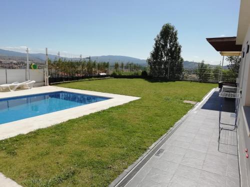 a large backyard with a swimming pool and a yard at VillaTerreno Casa Rural en Logroño in Villamediana de Iregua