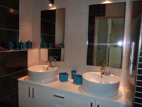 deux lavabos dans une salle de bain avec deux miroirs dans l'établissement Beau studio vu mer juan les pins, à Antibes