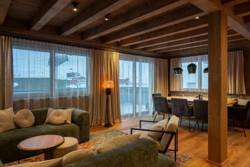 a living room with a couch and a table and chairs at Luf Lodges in Ischgl
