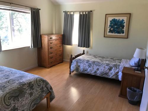 a bedroom with two beds and a dresser and windows at Black Oak Hill Vista near Yosemite - mountain views & starry night sky in Mariposa