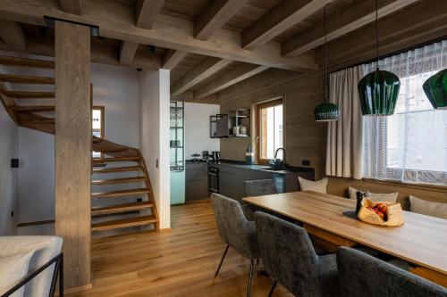 Il comprend une cuisine et une salle à manger avec une table et des chaises en bois. dans l'établissement Luf Lodges, à Ischgl