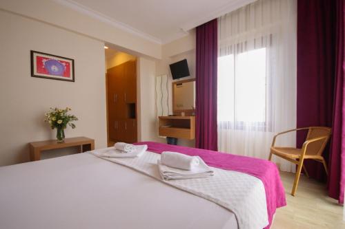 1 dormitorio con 1 cama con 2 toallas en Siriusmi Hotel, en Cesme