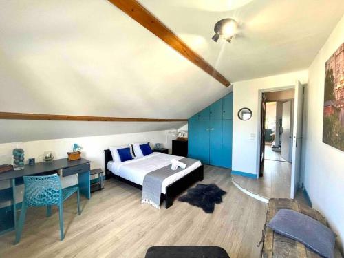 ein Schlafzimmer mit einem Bett und einem Schreibtisch und einem Bett sidx sidx sidx in der Unterkunft La Casa Del Papa - Maison spacieuse avec jardin in Dole