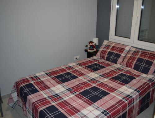 a bedroom with a bed with a plaid blanket at Loft at Sokratous in Athens