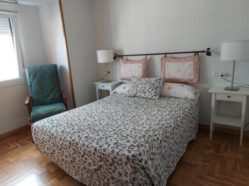 um quarto com uma cama e uma cadeira em Cimadevilla Apartamento San Pedro em Gijón