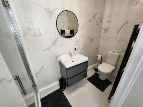 a bathroom with a sink and a toilet and a mirror at 2 Victoria Place - Luddendenfoot in Luddenden Foot