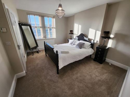 a bedroom with a bed and a large mirror at 2 Victoria Place - Luddendenfoot in Luddenden Foot