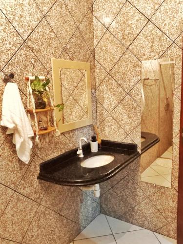 a bathroom with a sink and a mirror at Aquiri Hostel in Rio Branco