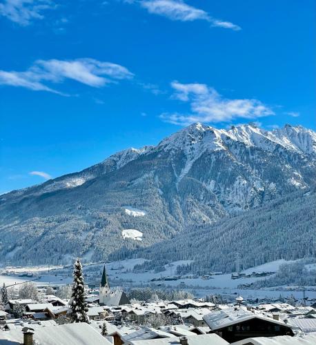 a snowy mountain range with a town in front of a mountain at Hotel Alta Vista in Neukirchen am Großvenediger