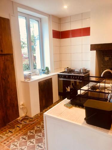 une cuisine avec une cuisinière et un comptoir dans l'établissement L'hôte des voyageurs en pays limousin 1, à Lacelle