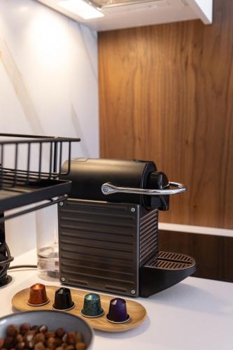 a coffee maker on a counter with a plate ofnuts at Glečer Kop, Cozy design apartment A5, FREE Parking Garage in Kopaonik