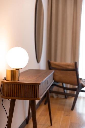 a table with a lamp on it next to a chair at Glečer Kop, Cozy design apartment A5, FREE Parking Garage in Kopaonik