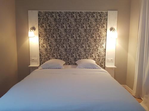 a bedroom with a large bed with two pillows at Beaune Residence appartement in Beaune