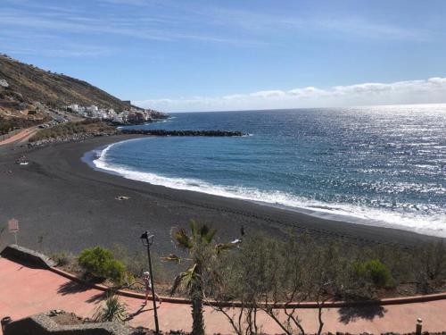 a beach with a black sand and the ocean at La casita de Mon - Radazul in Radazul