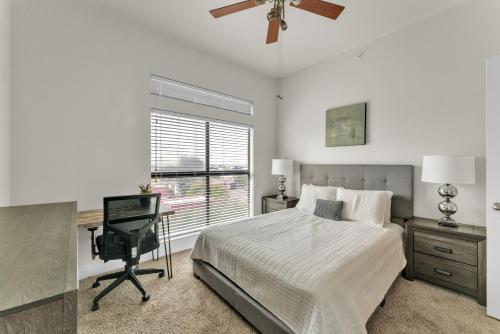 Schlafzimmer mit einem Bett, einem Schreibtisch und einem Fenster in der Unterkunft Stunning 1 Bedroom Condo , Pool, Gym, Parking, Cs in Dallas