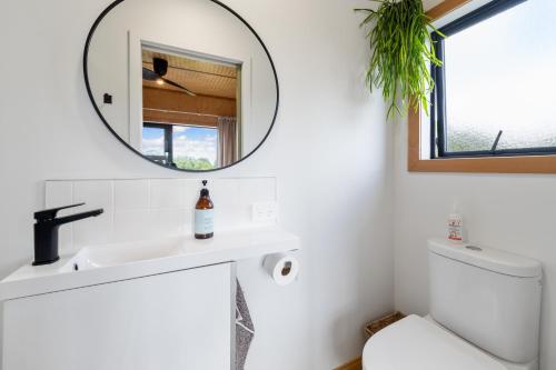 a bathroom with a sink and a mirror at Kūkū Kabin - Waimate North Eco Holiday Cabin in Kerikeri