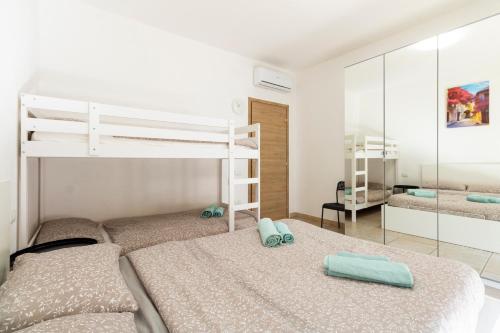 a bedroom with two bunk beds and a mirror at Secret Paradise & SPA Rooftop in Quartu SantʼElena