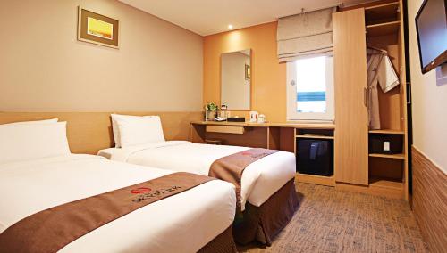 ソウルにあるホテル スカイパーク ミョンドン 3のベッド2台とテレビが備わるホテルルームです。