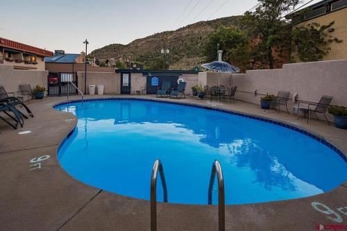 a large blue swimming pool with chairs around it at The Durango Lodge in Durango