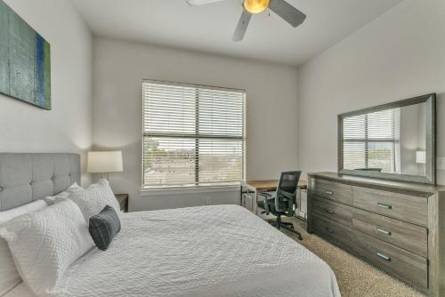 a bedroom with a bed and a desk and a dresser at Corporate Modern Apt , Pool, Gym, Parking Cs in Dallas