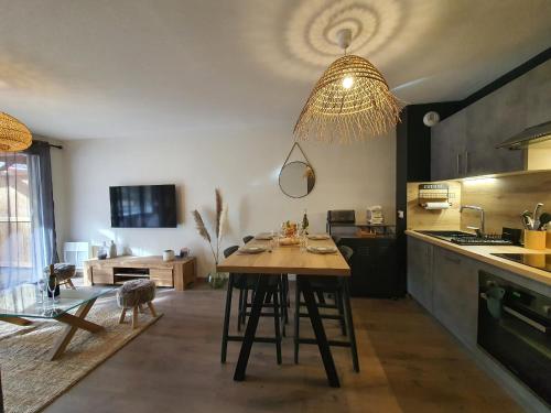 une cuisine avec une table en bois et un lustre dans l'établissement Magnifique appt NEUF 6 pers - vue montagne St Lary - curistes ok, à Vielle-Aure
