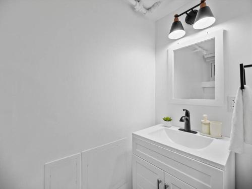 Baño blanco con lavabo y espejo en Shadyside, Pittsburgh, Modern and Quiet 1 Bedroom Unit1 with Free Parking en Pittsburgh