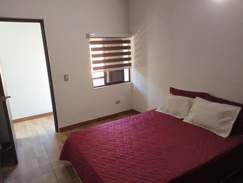 a bedroom with a red bed and a window at Hermoso apartamento en Medellín in Medellín