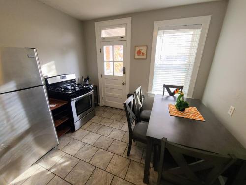 uma cozinha com uma mesa e um frigorífico de aço inoxidável em 6600A Arsenal First Floor One Bedroom One Bath in South City em Ellendale