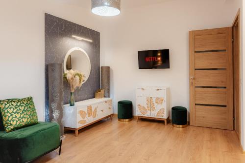 a living room with a green chair and a mirror at Duplex lux - Thoria in Bucharest