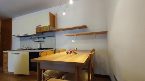 una cocina con una mesa de madera con sillas y una cocina gmaxwell gmaxwell gmaxwell en Casa Aprica piste da sci Baradello, en Aprica