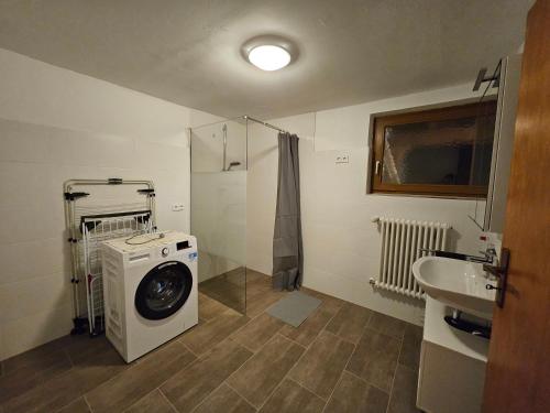 a bathroom with a washing machine and a sink at T&G WirthHaus in Bad Rappenau