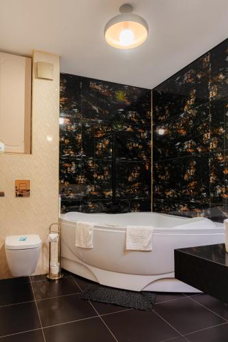 a bathroom with a bath tub and a toilet at Duplex lux - Thoria in Bucharest