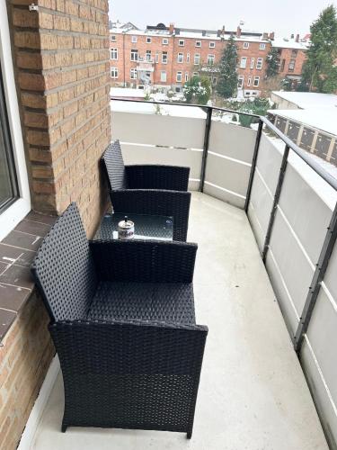 Un balcón con dos sillas y una mesa. en Stilvolles Studio Apt. Lübeck Zentrum, en Lübeck
