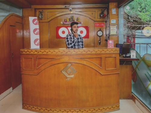 a wooden counter with a picture of a man at Hotel Cozy Residency in Jabalpur